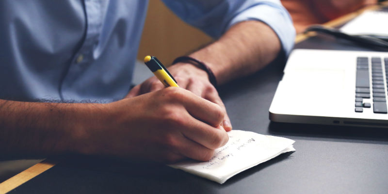 Person writing on notepad